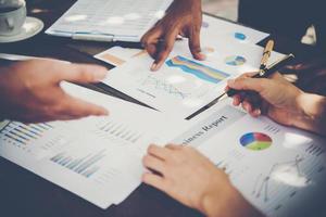 Group of business people analyze graphs at meeting photo