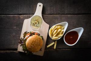 Hamburguesa de pollo casera con champagne y papas fritas foto