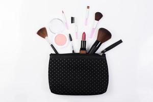 Vista superior de una bolsa de maquillaje con productos de belleza. foto