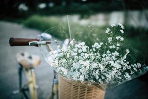 Vintage bicycle with a basket full of wild flowers photo