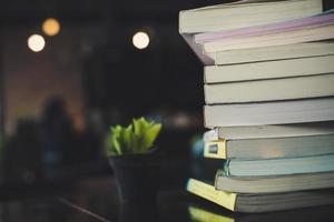 Piles of books on a table over a blurred library background photo