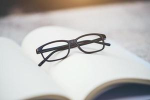 Black glasses on an open book photo