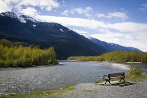 Bench by a river and mountain photo