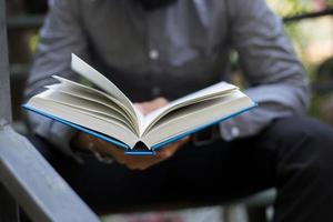 Young man reading books in home garden with nature photo