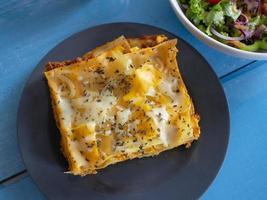 Homemade lasagna with a side salad photo