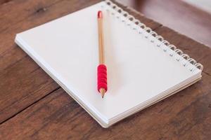 cuaderno y lápiz sobre una mesa de madera foto