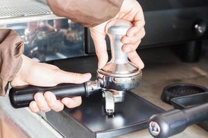 barista con un pisón para hacer espresso foto