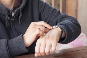 Person checking the time on a wristwatch photo