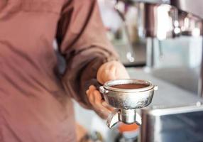 Close-up of a woman holding a coffee grinder photo