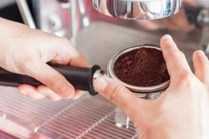 Barista putting in fresh espresso photo