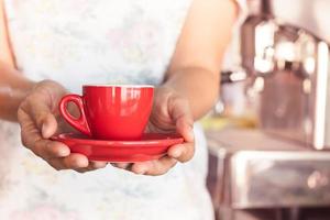 Woman holding a red coffee cup photo