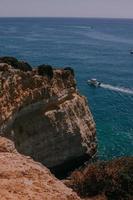 Boat cruising near a cliff photo