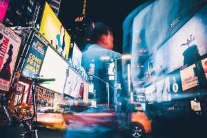 Man in blue shirt standing near cars during night time photo