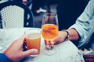 Two people holding alcoholic drinks photo