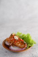 Spicy sardine salad in a wooden bowl photo