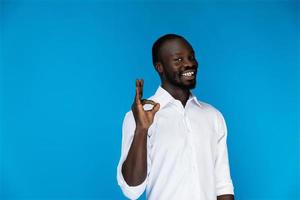 Smiling guy shows the okay sign with his fingers photo