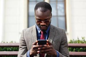 Man wearing sunglasses is working on his phone