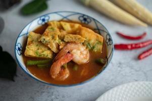 Hot and sour soup with cha-om, egg, and shrimp photo
