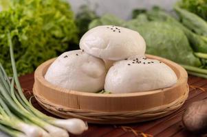 Steamed buns in a wooden dish photo