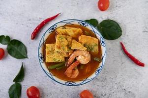 Hot and sour soup with cha-om, egg, and shrimp photo