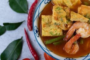 Hot and sour soup with cha-om, egg, and shrimp photo