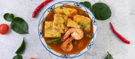 Hot and sour soup with cha-om, egg, and shrimp photo
