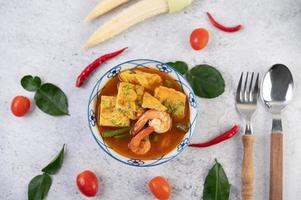 Hot and sour soup with cha-om, egg, and shrimp photo