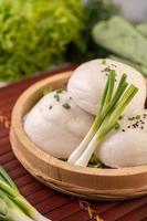 Steamed buns in a wooden dish photo