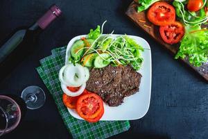 Bistec a la parrilla y verduras en un plato foto