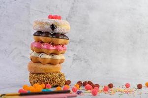 A stack of assorted donuts and toppings photo