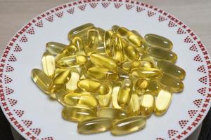 omega 3 cápsulas de aceite de pescado dorado en plato foto