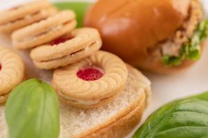 Bread slices with cookies and vegetables and a burger photo