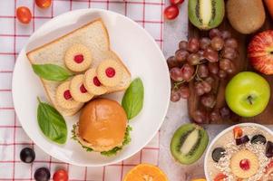 Bread slices with cookies and vegetables and a burger photo