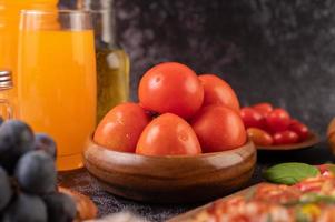 tomates frescos, uvas y jugo de naranja en un vaso