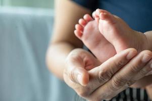Mothers' hands holding baby feet photo