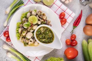 Spicy squid salad with onion and tomatoes photo