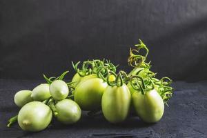 tomates verdes sobre un fondo negro foto