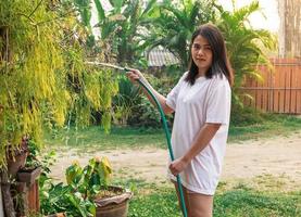 Woman outside watering plants photo