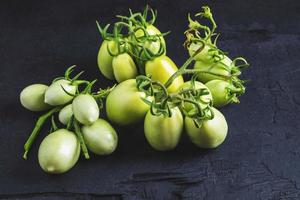 Green tomatoes on a black surface photo