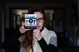 chica usando una cámara polaroid foto