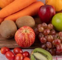 Close-up de manzanas, uvas, zanahorias y naranjas. foto