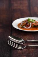 Selective focus of stainless spoon and fork on wooden table photo