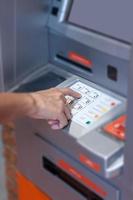 Close-up of a person using an ATM machine photo