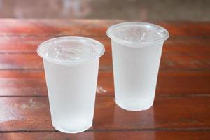 Two glasses of water on a wooden table photo