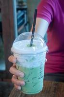 Green tea frappe in  a hand photo
