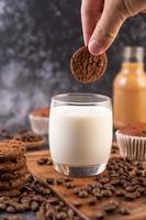 Hand dipping a cookie in milk photo
