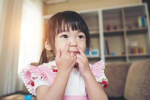 Retrato de una niña asiática jugando en su casa foto