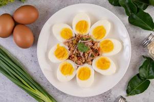 medio huevos cocidos con tomates y cebolletas foto