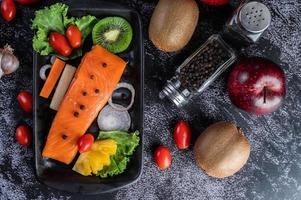 Raw salmon fillet with pepper, kiwi, pineapples, and rosemary photo