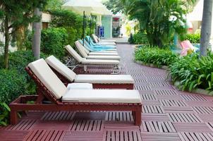Beach chairs near swimming pool in tropical resort photo